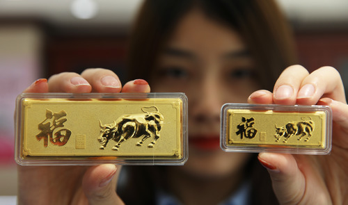 一家金店的工作人员展示贺岁金条。新华社发（赵晓明 摄）