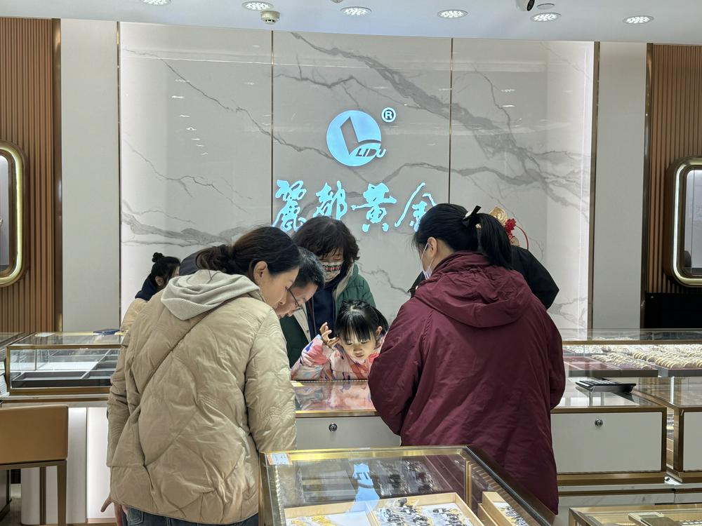 （一家老少正在郝润松的店内挑选金饰 财联社记者摄）