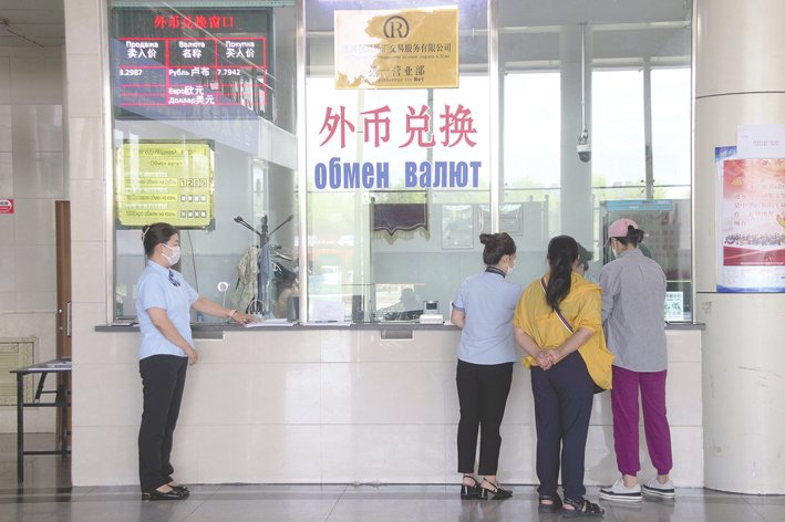2024年8月1日，黑龙江省黑河市，游客在黑河口岸黑河创融外汇交易服务有限公司窗口兑换外币或者人民币。 视觉中国图