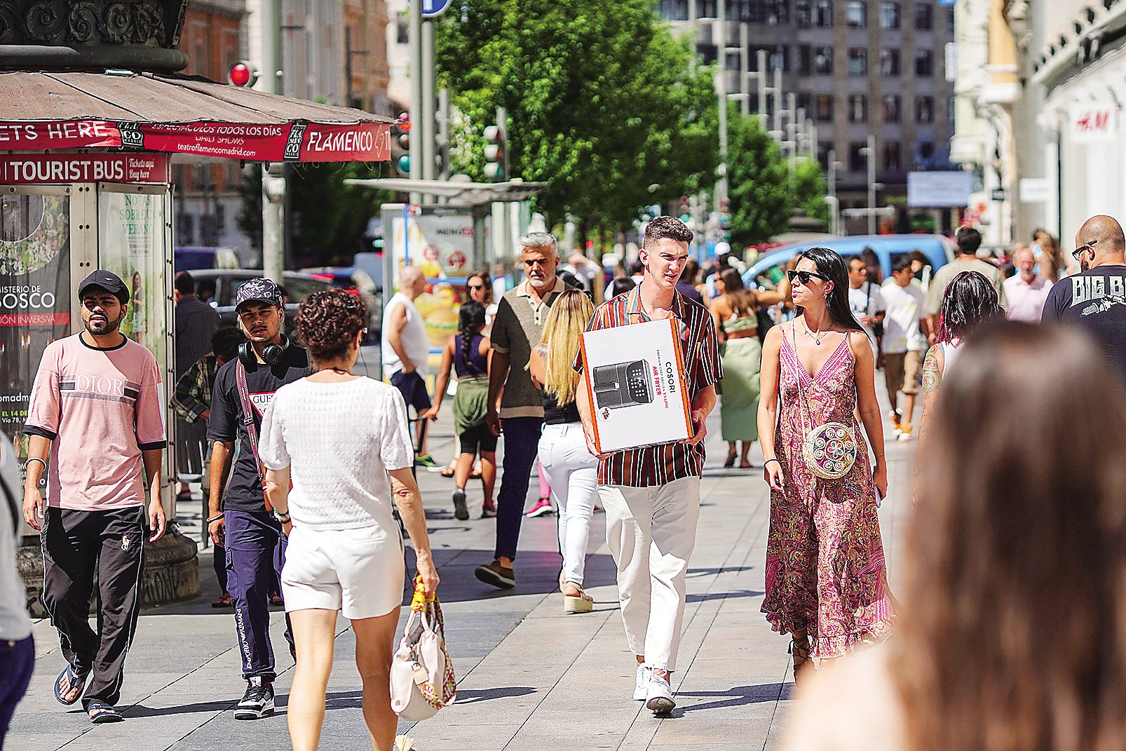 图为西班牙马德里民众走在商业街上。